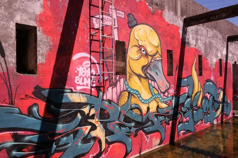 Rote und gelbe Graffiti auf den Wänden eines offenen Gebäudes.